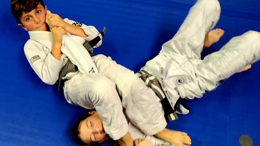 Two pre-teen students practicing an armlock technique during a martial arts class at Next Generation Martial Arts Thibodaux.