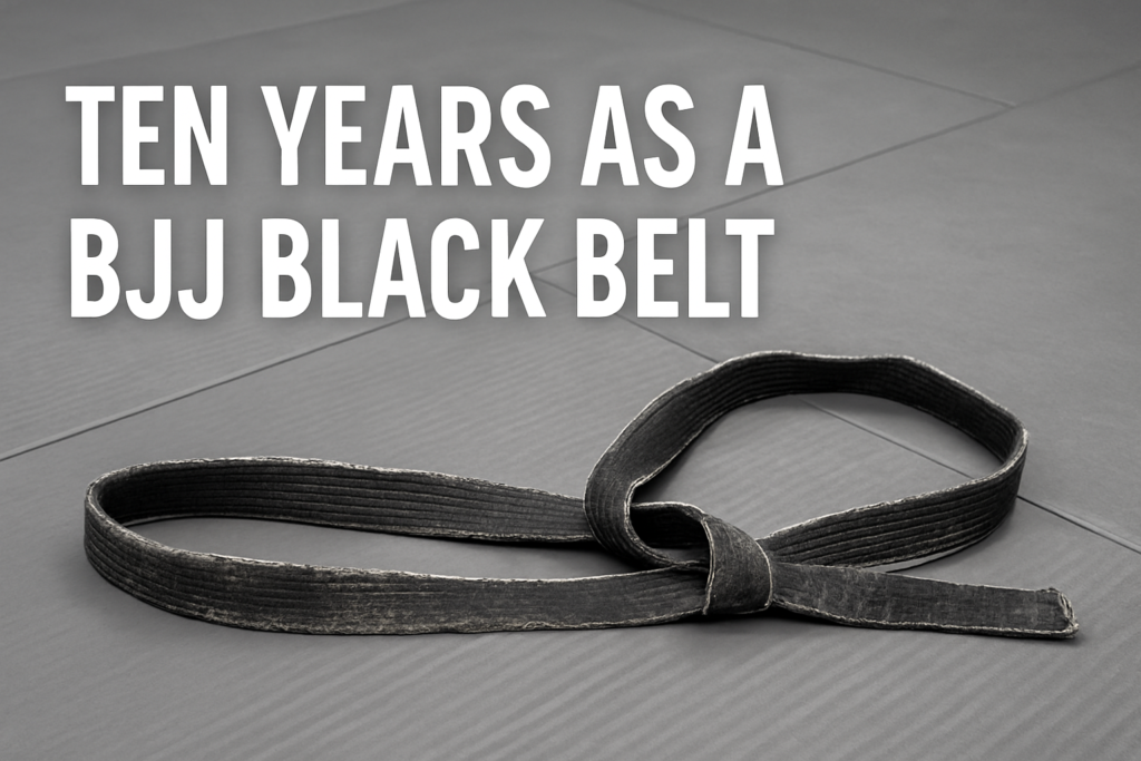 Tattered BJJ black belt resting on gray mats for bjj black belt lessons blog post